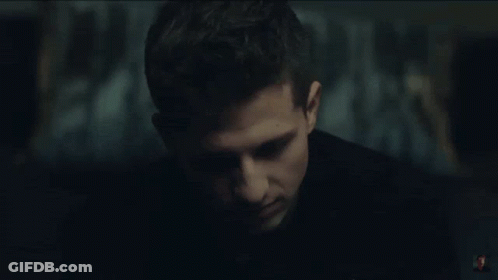 A Close Up Of A Man 'S Face In A Dark Room With A Blurry Background . GIF