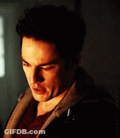 A Close Up Of A Man 'S Face In A Dark Room With A Hoodie On GIF