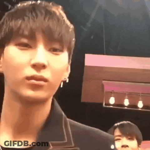 A Close Up Of A Man 'S Face In A Dark Room With A Pink Background . GIF
