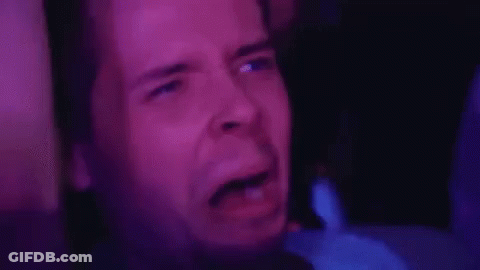 A Close Up Of A Man 'S Face In A Dark Room With A Purple Background . GIF