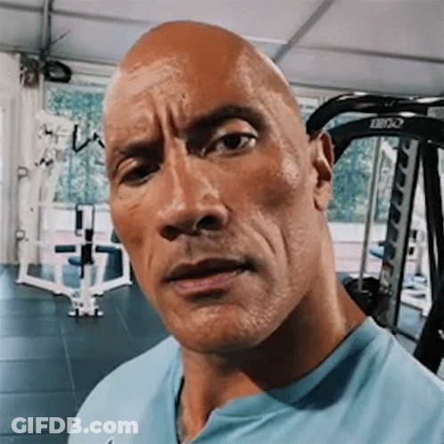A Close Up Of A Man 'S Face In A Gym With A Machine In The Background . GIF