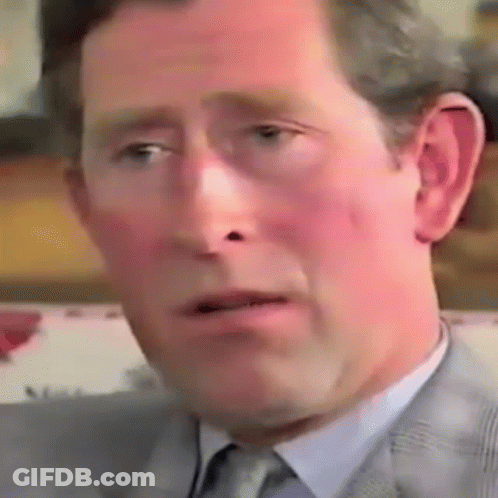 A Close Up Of A Man 'S Face In A Suit And Tie Making A Funny Face . GIF