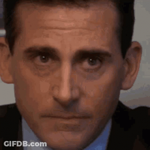 A Close Up Of A Man 'S Face In A Suit And Tie Making A Funny Face . GIF