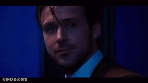 A Close Up Of A Man 'S Face In A Suit And White Shirt In A Dark Room . GIF