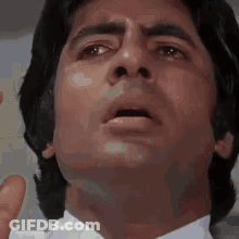 A Close Up Of A Man 'S Face In A White Shirt And Tie . GIF