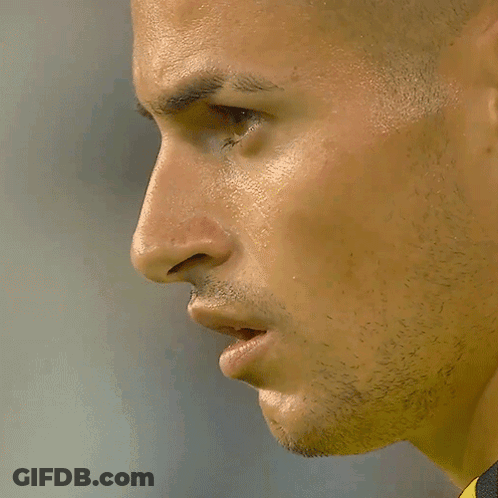A Close Up Of A Man 'S Face In A Yellow And Black Shirt GIF