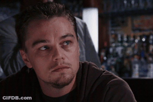 A Close Up Of A Man 'S Face In Front Of A Bar With Bottles Of Alcohol GIF