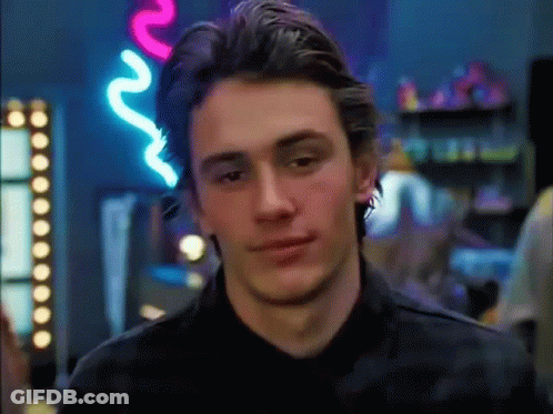 A Close Up Of A Man 'S Face In Front Of A Neon Sign That Says R. GIF