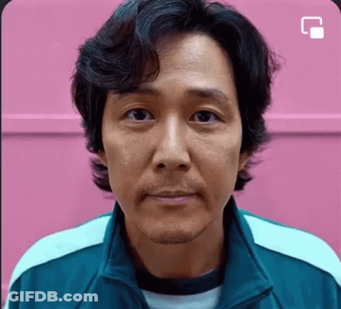 A Close Up Of A Man 'S Face In Front Of A Pink Wall . GIF