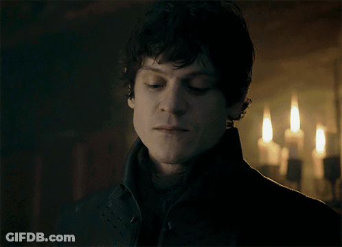 A Close Up Of A Man 'S Face In Front Of Candles GIF