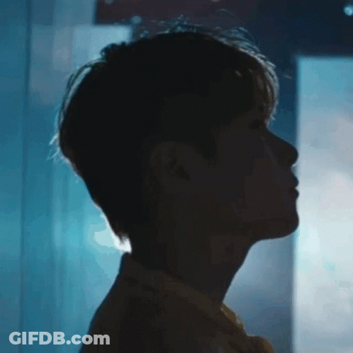 A Close Up Of A Man 'S Face In The Dark With A Blue Background . GIF