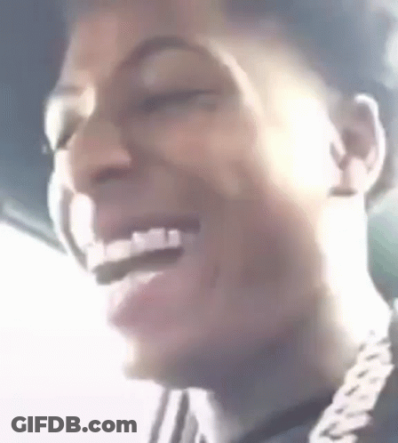 A Close Up Of A Man 'S Face Laughing With His Eyes Closed And A Chain Around His Neck . GIF