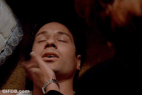 A Close Up Of A Man 'S Face Laying On A Bed GIF