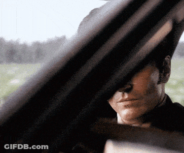 A Close Up Of A Man 'S Face Looking Out A Car Window GIF