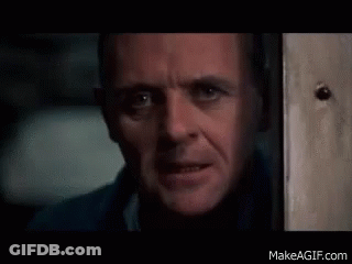 A Close Up Of A Man 'S Face Looking Out A Door . GIF