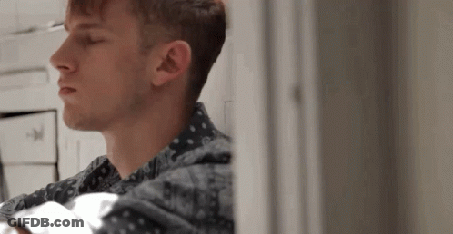 A Close Up Of A Man 'S Face Looking Out A Window GIF