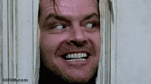 A Close Up Of A Man 'S Face Looking Through A Hole In A Wall . GIF