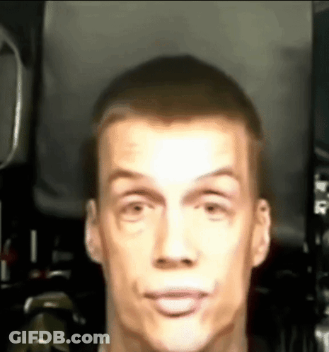 A Close Up Of A Man 'S Face Making A Funny Face In A Dark Room . GIF