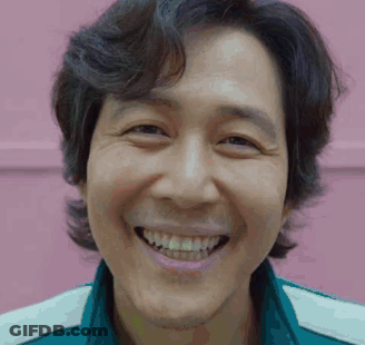 A Close Up Of A Man 'S Face Smiling Against A Pink Background . GIF