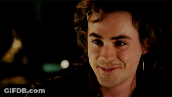 A Close Up Of A Man 'S Face Smiling With A Piercing In His Ear GIF