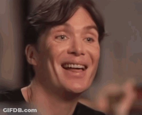 A Close Up Of A Man 'S Face Smiling With His Mouth Open GIF