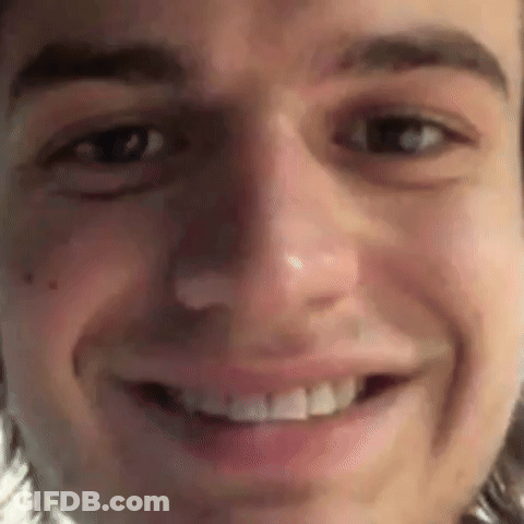 A Close Up Of A Man 'S Face Smiling With His Mouth Open . GIF