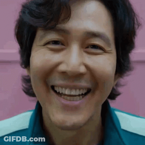 A Close Up Of A Man 'S Face Smiling With His Teeth Showing . GIF