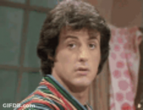 A Close Up Of A Man 'S Face Wearing A Colorful Shirt . GIF