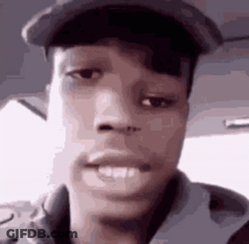 A Close Up Of A Man 'S Face Wearing A Hat And A Jacket . GIF