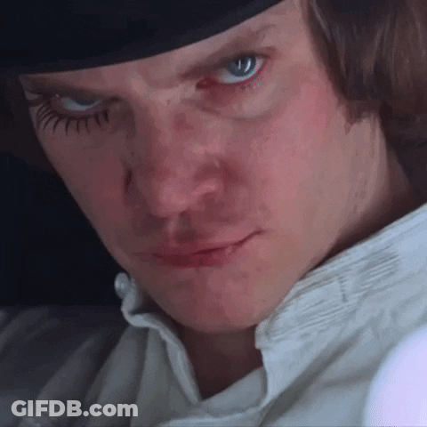 A Close Up Of A Man 'S Face Wearing A Hat And A White Shirt . GIF