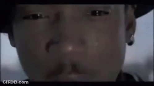 A Close Up Of A Man 'S Face Wearing A Hat And Earring . GIF