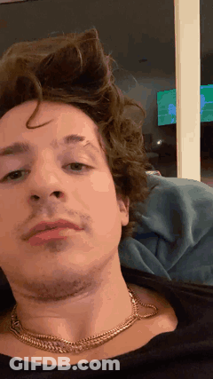 A Close Up Of A Man 'S Face Wearing A Necklace GIF