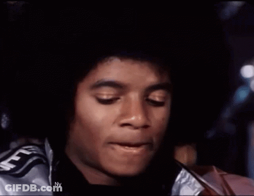 A Close Up Of A Man 'S Face Wearing A Silver Jacket With The Word Supreme On It . GIF
