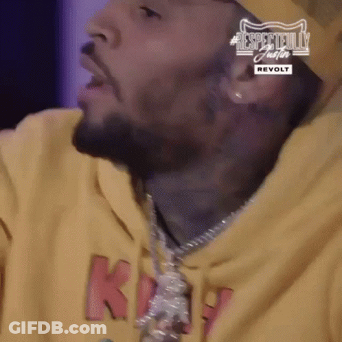 A Close Up Of A Man 'S Face Wearing A Yellow Hoodie And A Necklace . GIF