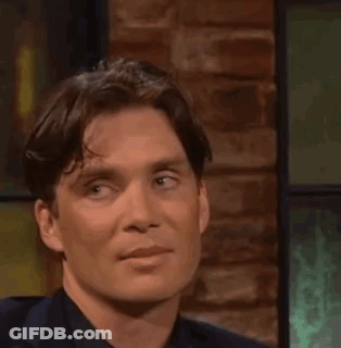 A Close Up Of A Man 'S Face While Sitting In Front Of A Brick Wall . GIF