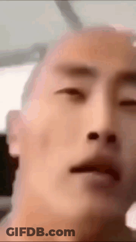 A Close Up Of A Man 'S Face With A Bald Head GIF