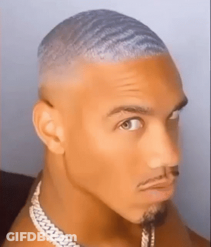 A Close Up Of A Man 'S Face With A Beard And A Necklace On . GIF