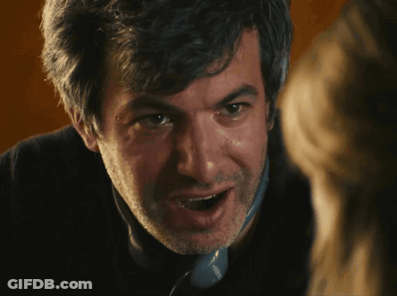 A Close Up Of A Man 'S Face With A Beard And A Phone That Says ' Siemens ' On The Side GIF
