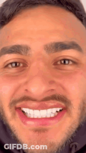 A Close Up Of A Man 'S Face With A Beard And A Smile On His Face . GIF