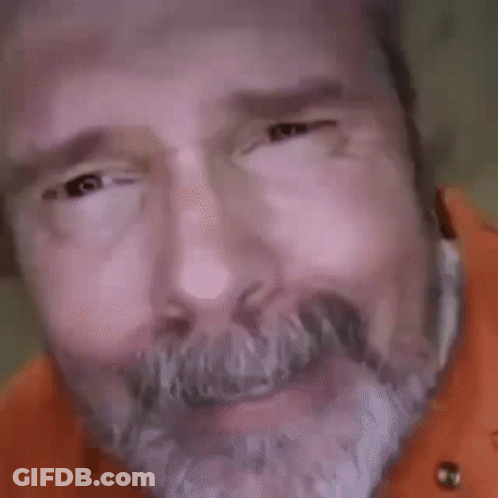 A Close Up Of A Man 'S Face With A Beard And Big Eyes Looking At The Camera . GIF