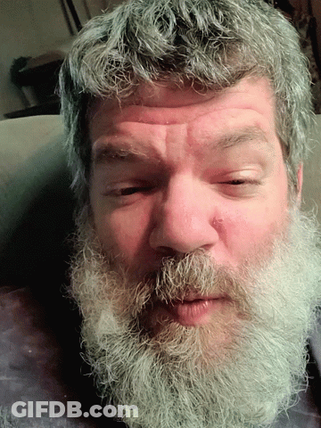 A Close Up Of A Man 'S Face With A Beard And Gray Hair GIF