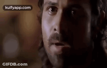 A Close Up Of A Man 'S Face With A Beard And Mustache Looking At The Camera . GIF