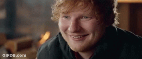 A Close Up Of A Man 'S Face With A Beard And Red Hair Smiling . GIF