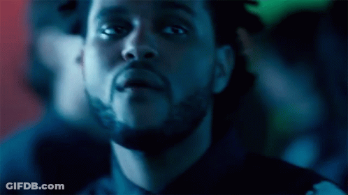 A Close Up Of A Man 'S Face With A Beard In A Dark Room GIF