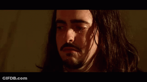 A Close Up Of A Man 'S Face With A Beard In A Suit And Tie . GIF