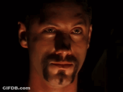 A Close Up Of A Man 'S Face With A Beard In The Dark GIF
