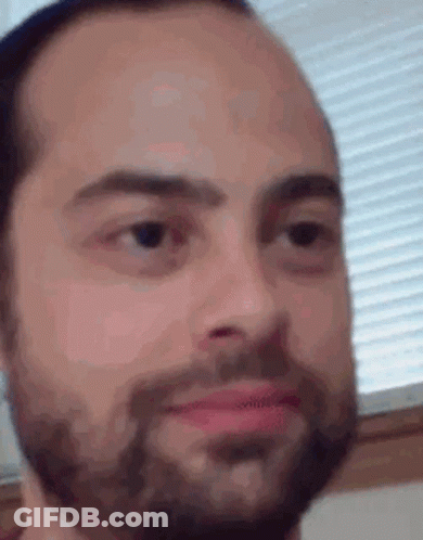 A Close Up Of A Man 'S Face With A Beard Looking At The Camera . GIF
