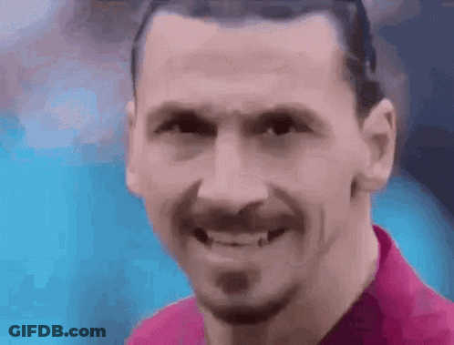 A Close Up Of A Man 'S Face With A Beard Smiling . GIF