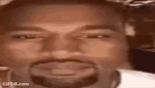 A Close Up Of A Man 'S Face With A Beard Smiling . GIF
