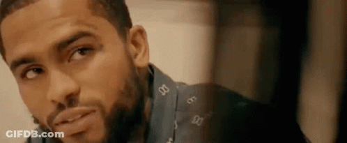 A Close Up Of A Man 'S Face With A Beard Wearing A Blue Shirt . GIF